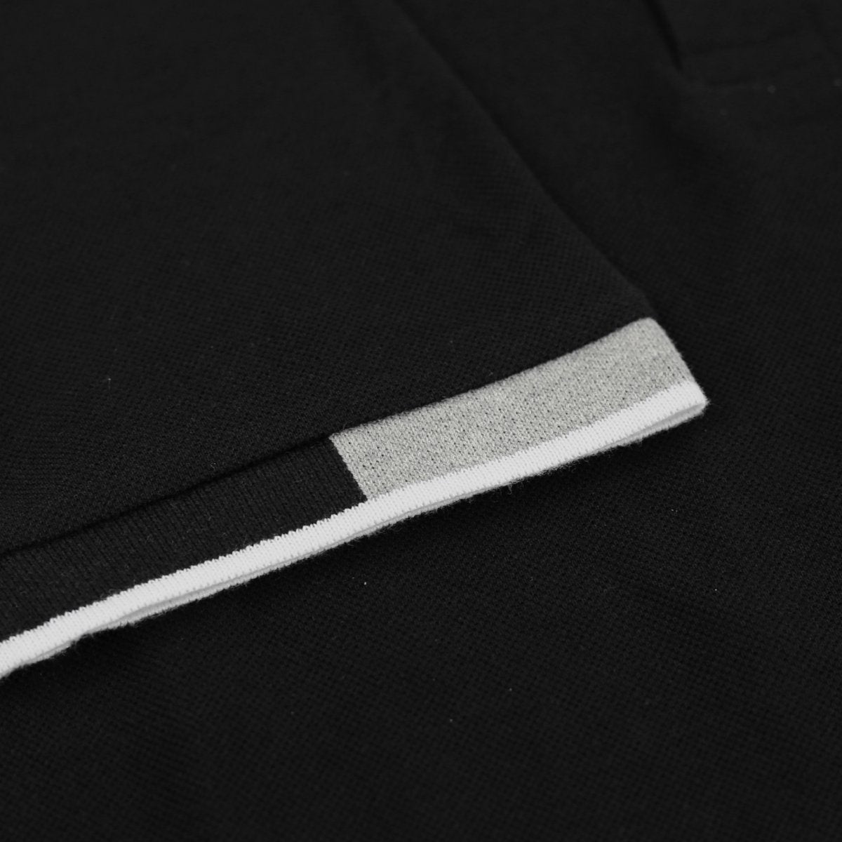 Dettaglio della polo Lotto Delta junior nera in cotone piquet traspirante e resistente, ideale per allenamenti e uso quotidiano dei ragazzi attivi