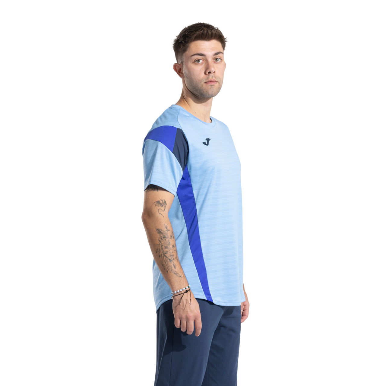 Vista laterale della maglia tennis Joma uomo, mostra vestibilità ergonomica e libertà di movimento per il tennis